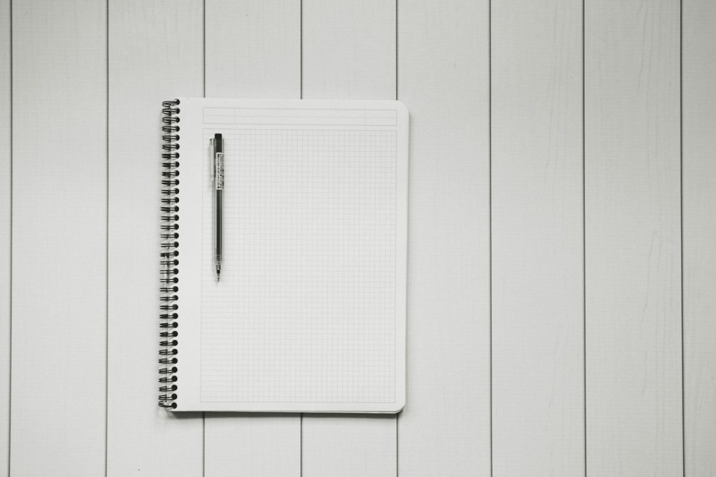 方眼ノートに記録を書き込む手元