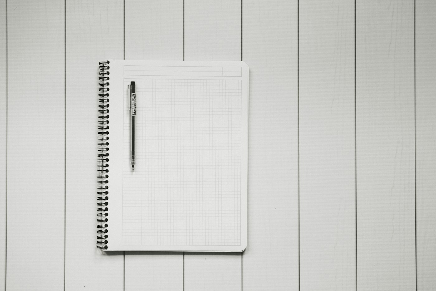 方眼ノートに記録を書き込む手元