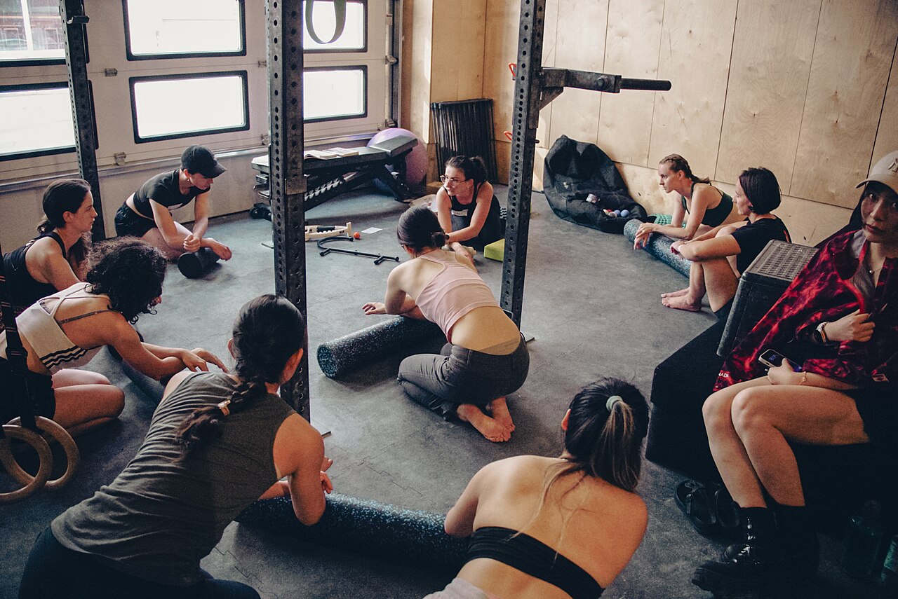 Personas estirando antes de entrenar en un gimnasio
